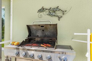Ein Grill mit einem Metallgriff, vier Reglern und einem dekorativen Wandelement darüber.
