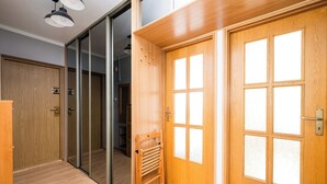 Une chambre d’hôtel avec une porte en bois, une porte-fenêtre coulissante et un banc en bois.