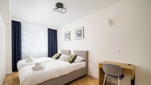 A modern bedroom with a double bed, a desk, and a chair. - Wrzeciono Comfortline Apartment (Warszawa)