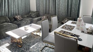 A modern living room with a sofa, chairs, a dining table, and patterned curtains. - Charming 1-bedroom house in fabulous Hamburg (Hamburg)