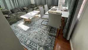 A modern living room with a sofa, coffee table, and dining table. - Charming 1-bedroom house in fabulous Hamburg (Hamburg)