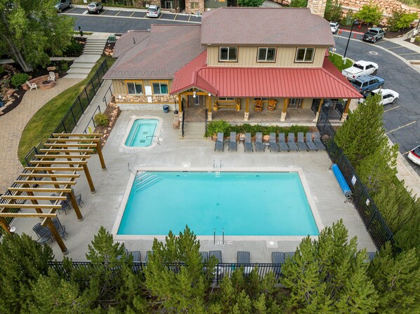 Un hotel con piscina, area salotto esterna e portico coperto.