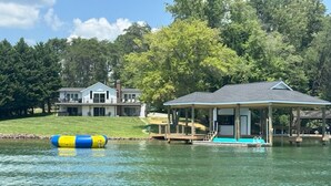 Una propiedad frente al lago con casa, muelle y piscina cubierta.