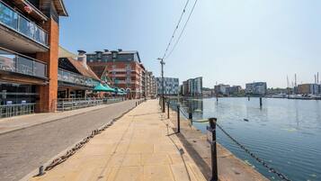Eine Uferpromenade mit einem Backsteinhaus, das ein Restaurant und ein Hotel beherbergt.