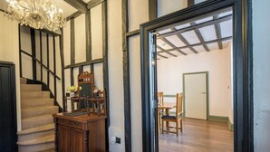 Una escalera con barandilla de madera, un escritorio de madera con un espejo y una araña.