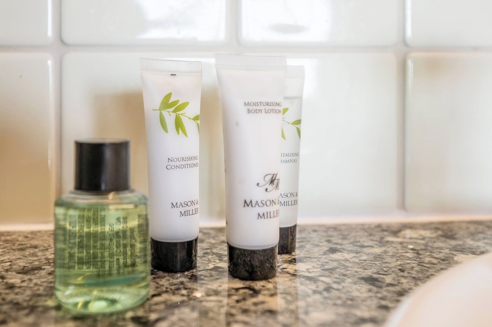 Three Mason & Miller toiletries on a bathroom countertop.