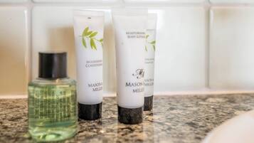 Three Mason & Miller toiletries on a bathroom countertop.