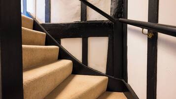 A staircase with beige carpeted steps and black handrails.