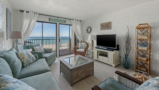 A living room with a sofa, a coffee table, a TV, and a bookshelf.