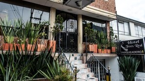 A hotel with a sign reading "Hotel Fenix Real" and "Parqueadero" indicating its location. - HOTEL FENIX REAL (Bogotá)