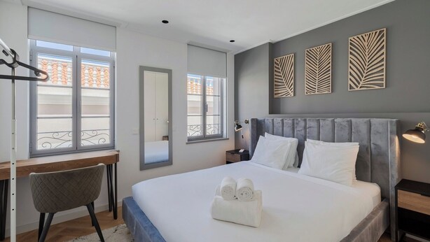 A modern hotel room with a large bed, a desk, and a chair. - Avenue Centro Casa, Setúbal (Setúbal)