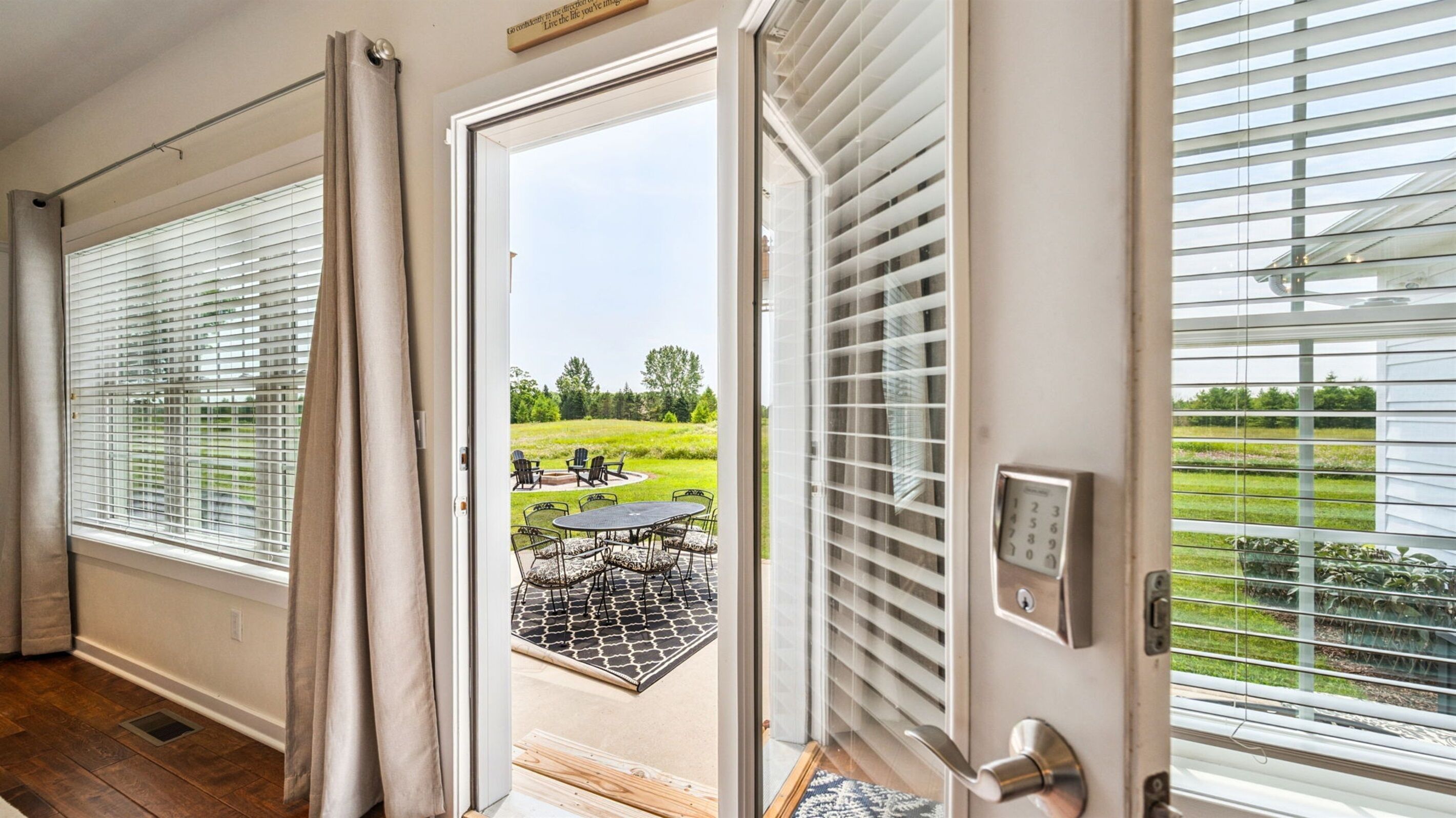A room with a sliding glass door leading to an outdoor patio with a table and chairs.