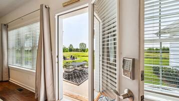 A room with a sliding glass door leading to an outdoor patio with a table and chairs.