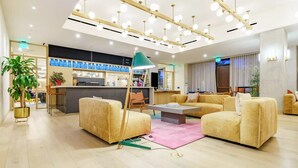 A modern hotel lobby with a seating area, a reception desk, and a bar. - Stylish Nativo I Modern 1 BDR Apt in Austin (Austin)