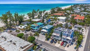 A coastal residential area with houses, a beach, and a clear view of the ocean.