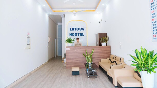 Un espace d’accueil moderne, avec un comptoir en bois, un canapé et des plantes en pot.