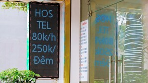L’entrée d’un hôtel, avec un panneau d’affichage numérique, des portes en verre et des plantes en pot.