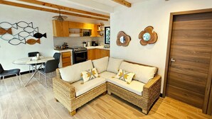Cocina moderna con armarios de madera, una mesa de comedor y un sofá.