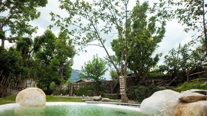 A natural pool surrounded by rocks and trees. - Krazy Gecko Resort (Pokhara)