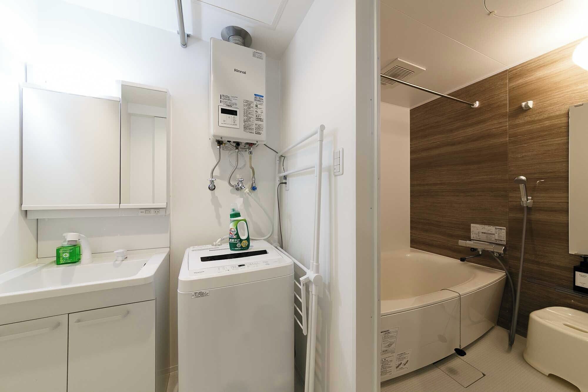 A modern bathroom with a built-in shower, a separate toilet, and a sink area.
