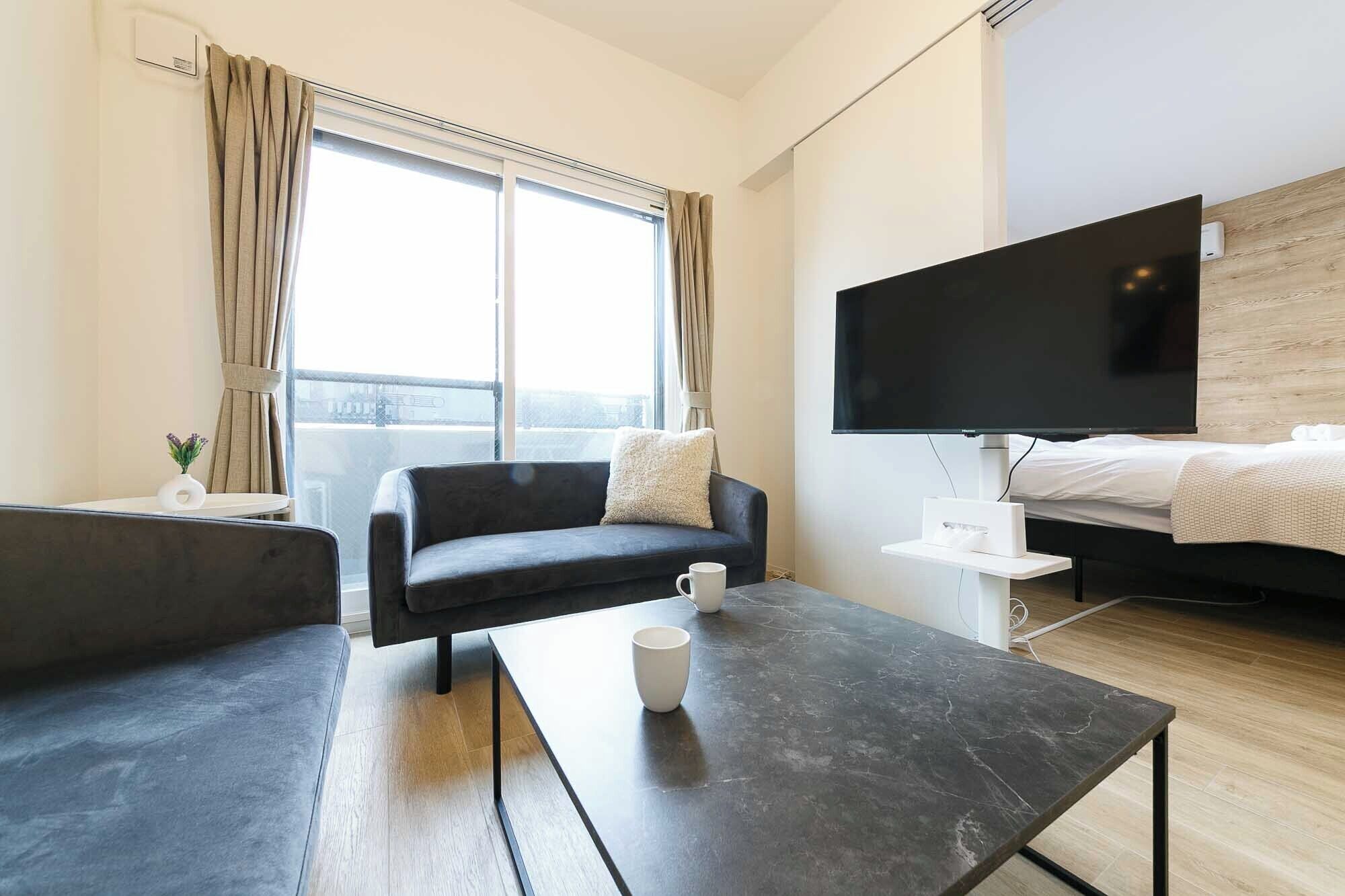 Ett modernt hotellrum med en soffa, ett soffbord, en TV och en säng.