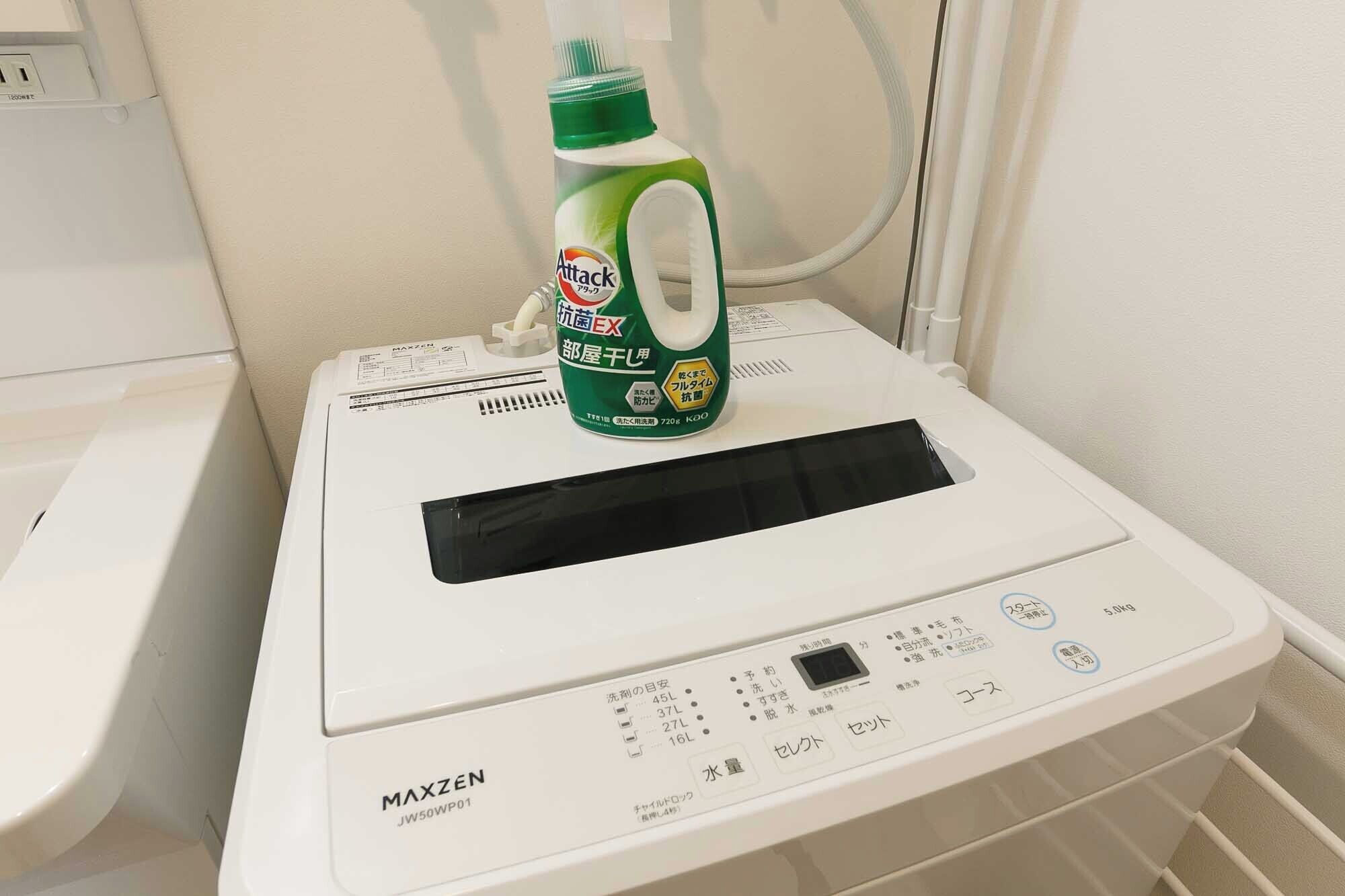 A white washing machine with a digital display and control panel, placed on a tiled floor.