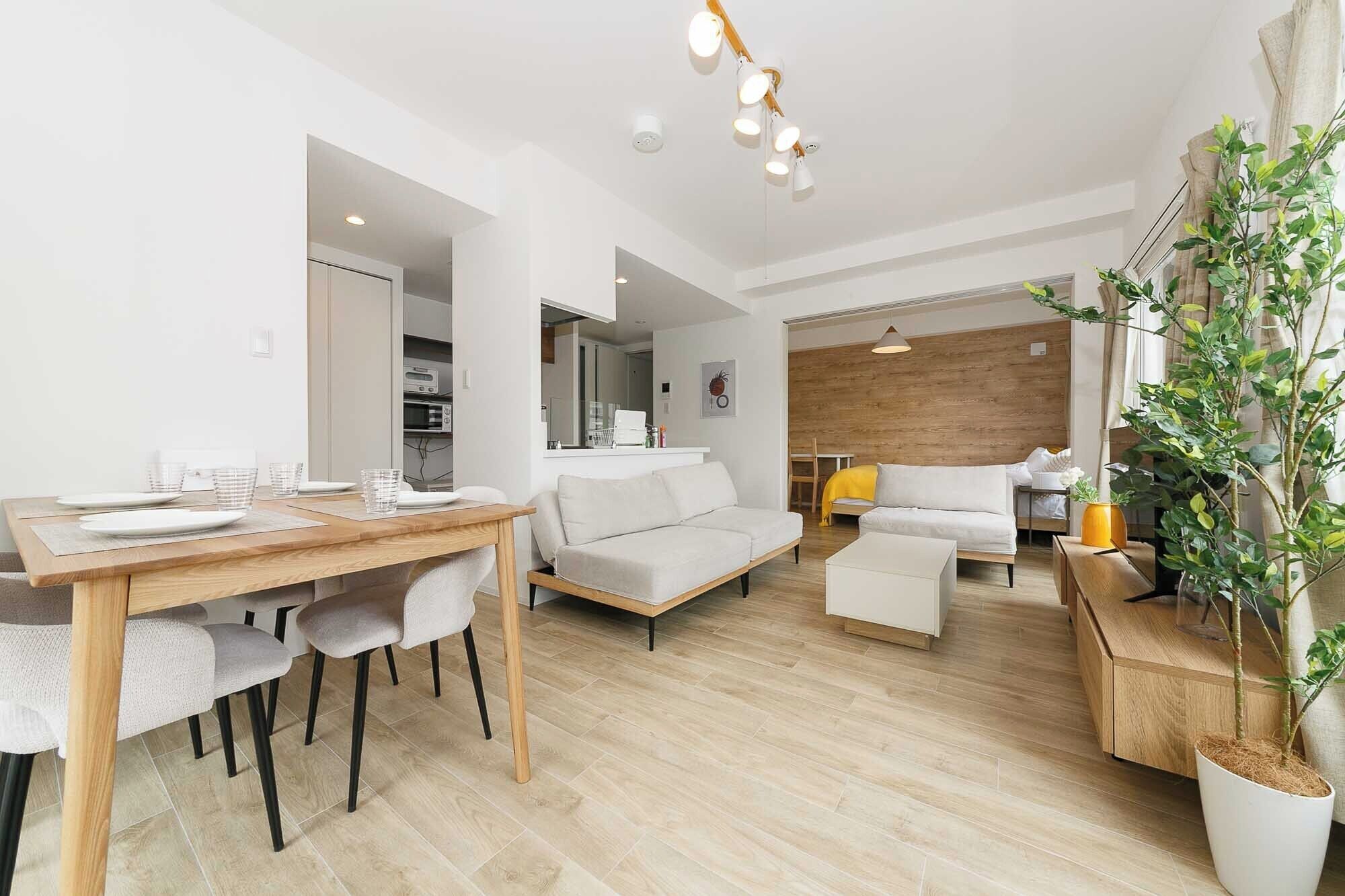 Un espacio habitable moderno con comedor, sofá y una planta.