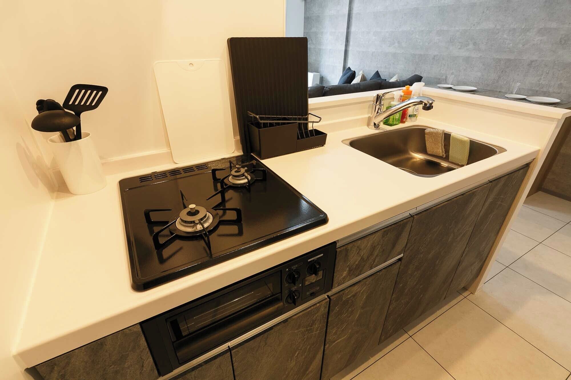 A compact kitchen with a gas stove, a sink, and a small countertop.