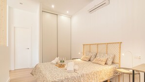 Ein Schlafzimmer mit Bett, Nachttisch und kleinem Tisch mit Lampe.