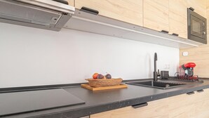 A modern kitchen with a black countertop, stainless steel appliances, and a wooden backsplash. - Calahonda Beach A, Mijas Costa, Spain (Mijas Costa)