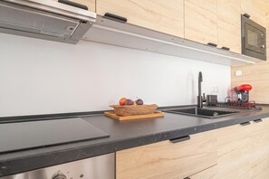A modern kitchen with a black countertop, stainless steel appliances, and a wooden backsplash. - Calahonda Beach A, Mijas Costa, Spain (Mijas Costa)
