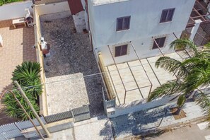 A multi-story building with a courtyard, outdoor seating, and a satellite dish. - Eurovillage Apartment with Pool & Terrace, Porto Cesareo, Italy (Porto Cesareo)