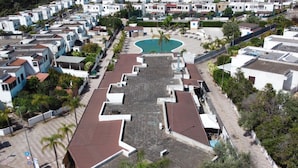 An aerial view of a residential area with multiple houses, a swimming pool, and a pedestrian pathway. - Eurovillage Apartment with Pool & Terrace, Porto Cesareo, Italy (Porto Cesareo)