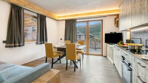 A modern kitchen with a dining area, a sofa, and a TV. - Livia, Livigno, Italy (Livigno)