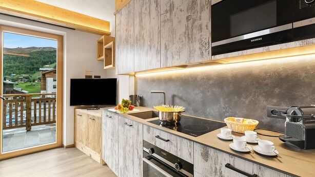 A modern kitchen with a built-in microwave, oven, and coffee maker. - Livia, Livigno, Italy (Livigno)