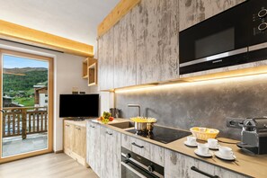 A modern kitchen with a built-in microwave, oven, and coffee machine.