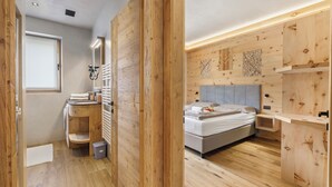 A modern bedroom with a wooden floor, a bed, a bedside table, and a wall-mounted shelf. - Livia, Livigno, Italy (Livigno)