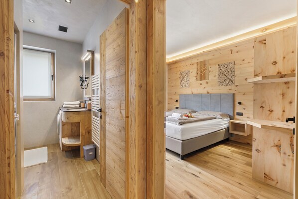 A modern bedroom with a wooden floor, a bed, a bedside table, and a wall-mounted shelf. - Livia, Livigno, Italy (Livigno)