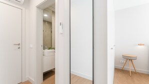 Moderni kylpyhuone, jossa on suihku, pesuallas ja pieni jakkara.