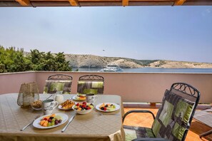 A table set with breakfast items and a view of a boat on a lake.
