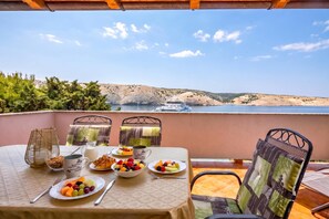 A table set with breakfast items and a view of a coastal landscape.