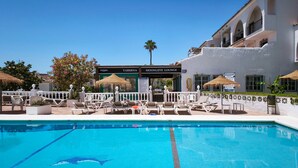 A pool with dolphin designs, lounge chairs, and a building with 'VICTORIA TABERNA MOONLITE LOUNGE' signage. - El Faro Hideaway by Lica Homes (Mijas)