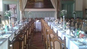 Een lange eettafel met stoelen, gedekt voor een maaltijd.