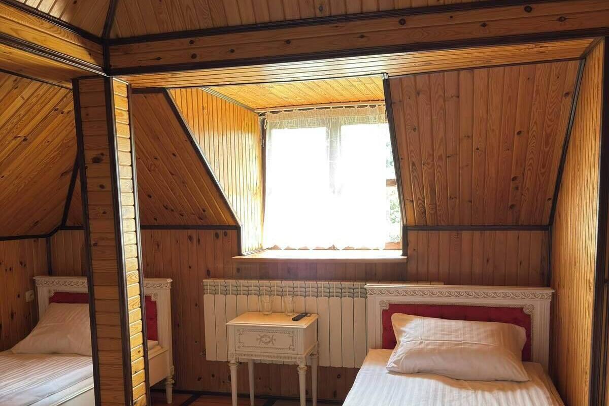 A room with two beds, a small table, and a window.