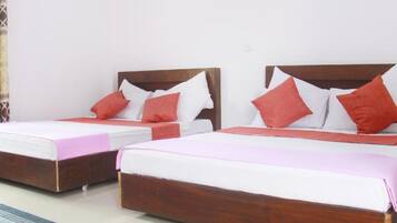 Two wooden beds with white and red bedding, a wooden headboard, and a wooden floor.