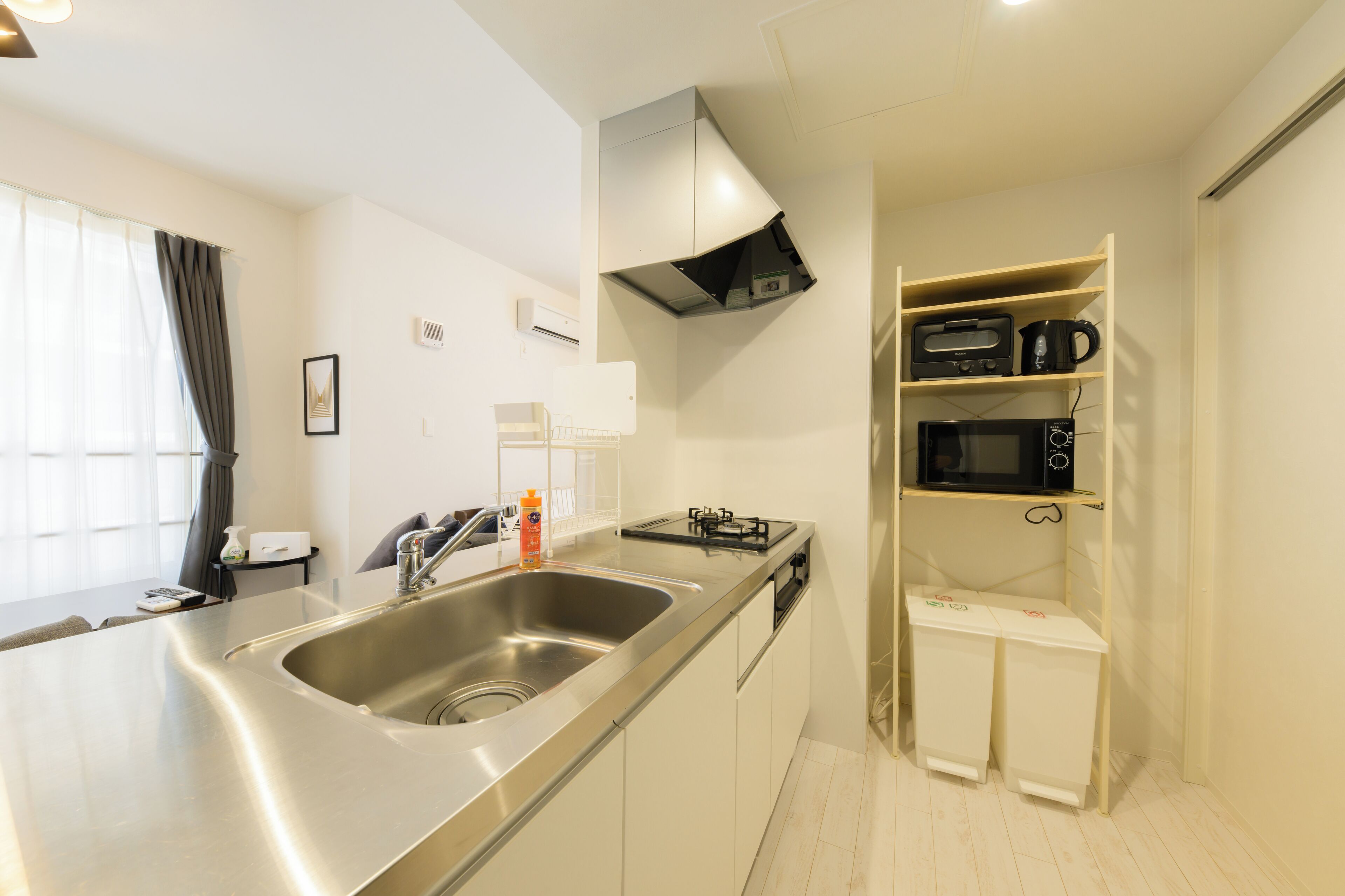 A modern kitchen with stainless steel appliances, a built-in sink, and a microwave shelf.