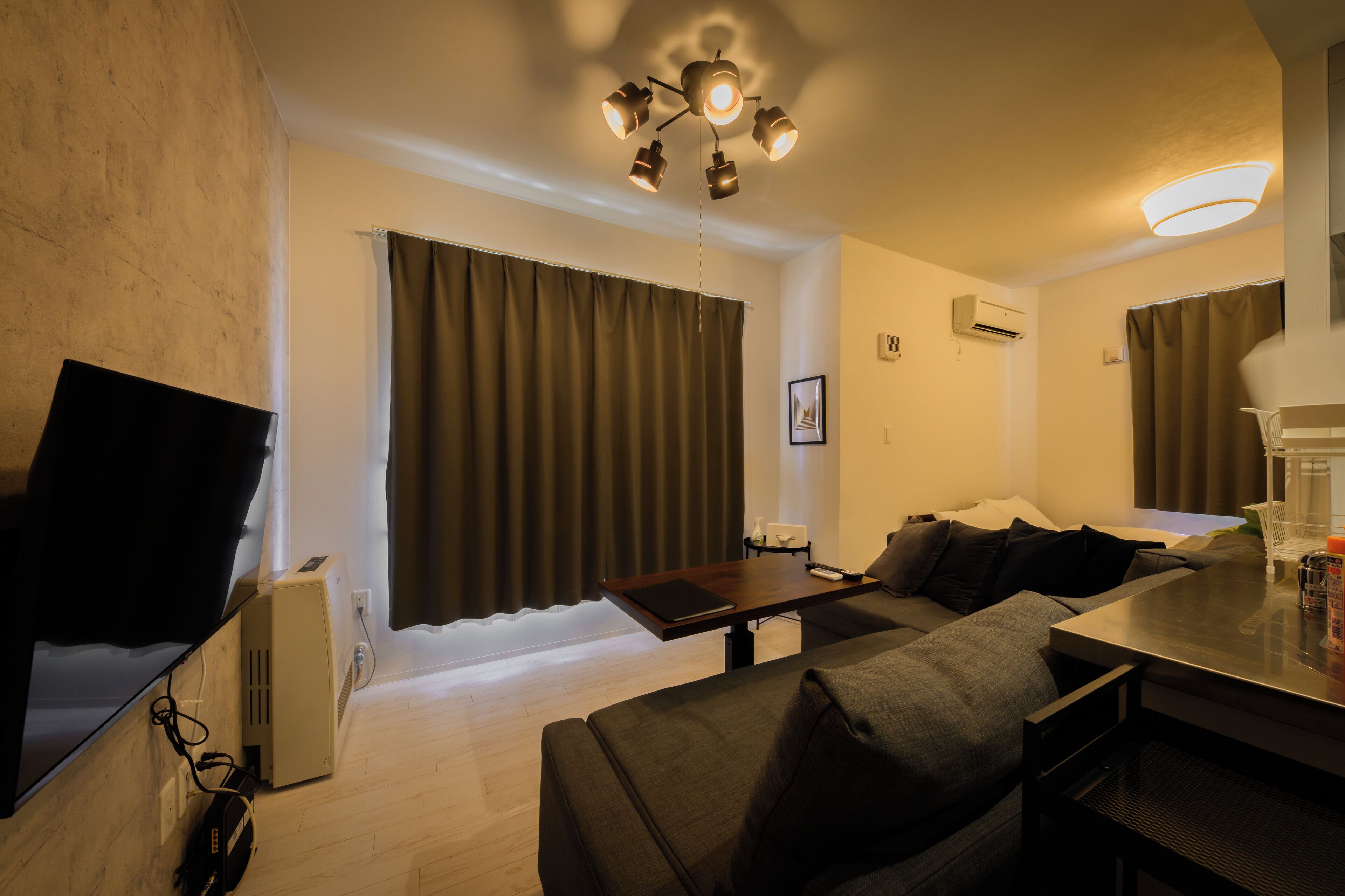 A modern living room with a sofa, a coffee table, and a TV.