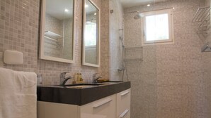 Ein Badezimmer mit Waschbecken, Spiegel und Dusche.