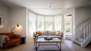 Een moderne woonkamer met een bank, salontafel en een trap.