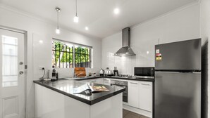 Cocina moderna con una isla central, electrodomésticos de acero inoxidable y un ventanal con vistas a zonas verdes.